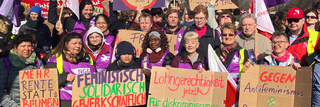 Ein Gruppenbild von Frauen beim 8. März mit Schildern.